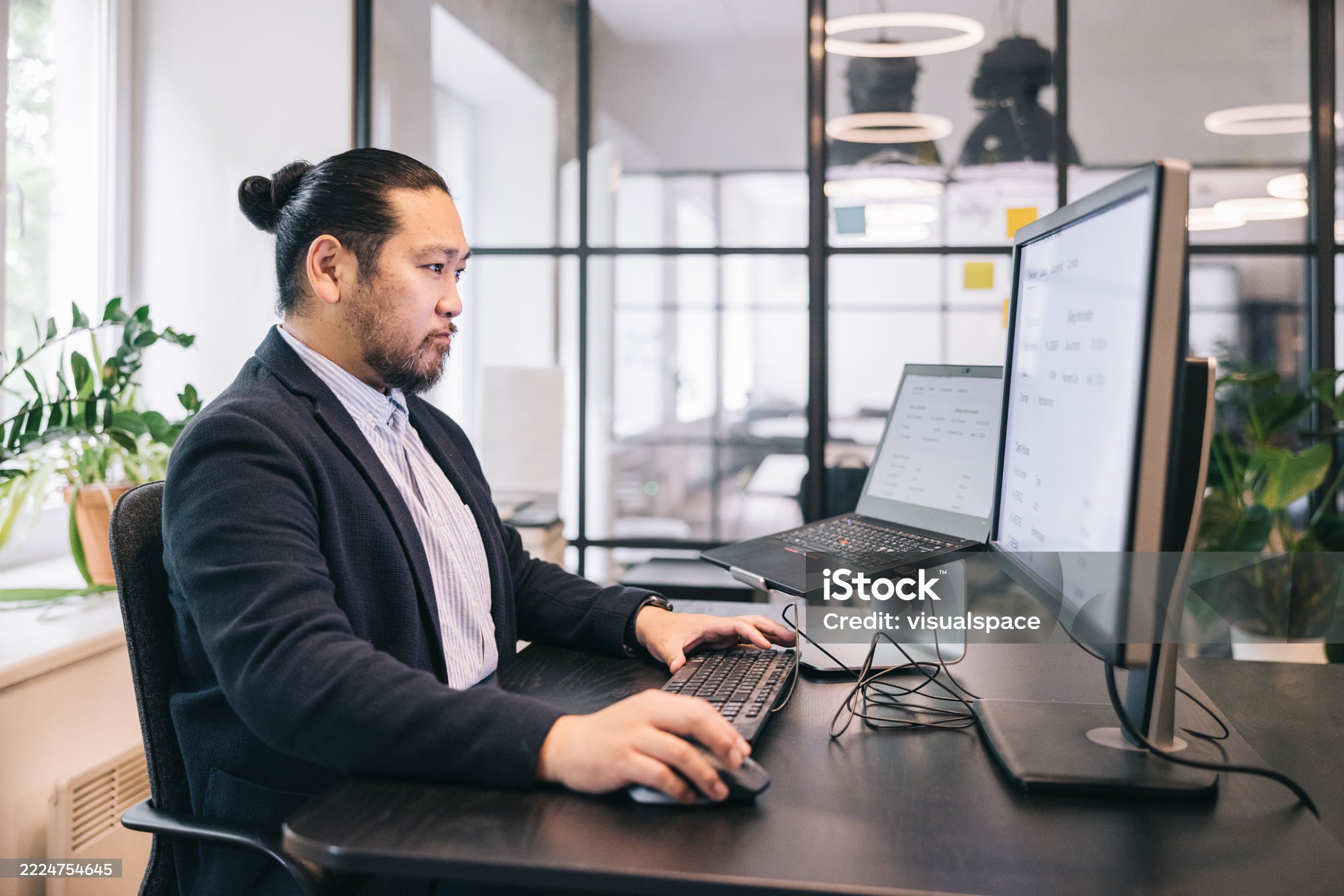 Learning and development administrator reviewing courses across two screens